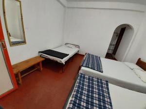 a small room with two beds and a mirror at Sanara Hotel in Nuwara Eliya +19 photos