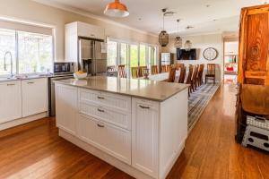 a kitchen with white cabinets and a large island at Hunter Moon in Broke