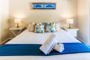 a bedroom with a large white bed with blue sheets and pillows at Hunter Moon in Broke +9 photos