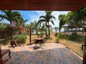a patio with a view of a beach with palm trees at Sunset Haven in Siquijor