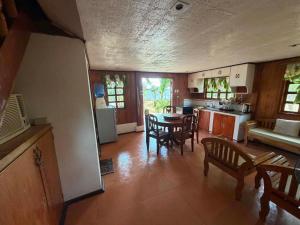 a kitchen and living room with a table and chairs at Sunset Haven in Siquijor