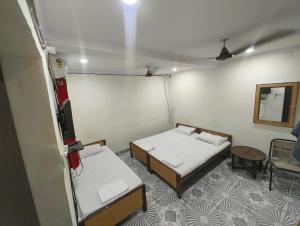 a room with two beds and a tv in it at Hotel Geetanjali in Lucknow +7 photos