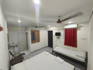 a room with two beds and a red curtain at Hotel Geetanjali in Lucknow