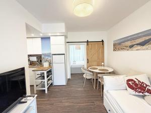 a kitchen and a living room with a couch and a table at Family Apartments Monika - sea view - heated pool II in Punat