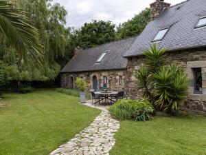 a stone house with a table in the yard at Escapade Bretonne in Lannion