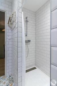 a bathroom with a shower with white tiles at Le logis du lièvre in Lodes +42 photos