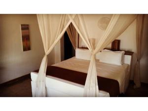 a bedroom with a bed with a canopy at Mikumi Wilderness Camp in Kikoboga +14 photos