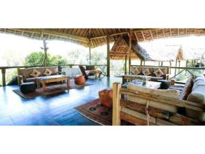 a living room with couches and tables in a pavilion at Mikumi Wilderness Camp in Kikoboga