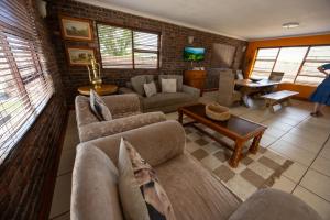 a living room with couches and a table at Colchester Suites - Travel Addo Group in Cannonvale