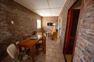 a dining room with a table and a brick wall at Colchester Suites - Travel Addo Group in Cannonvale