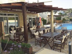 un patio con tavoli e sedie e una piscina di Lagada Resort a Makris Gialos