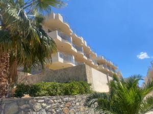 un edificio giallo con palme davanti di Lagada Resort a Makris Gialos Altre 124 foto