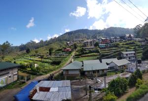 a small village on a hill with houses at Sanara Hotel in Nuwara Eliya