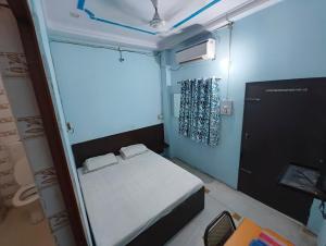 a small room with a bed and a window at Hotel Geetanjali in Lucknow