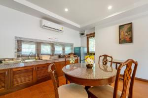 a kitchen with a table and a sink and a counter at Sailom Resort Bangsaphan in Bang Saphan