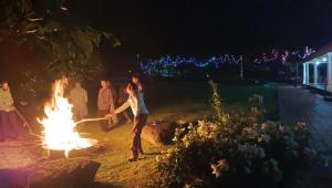 a group of people standing around a fire at Bougainvillea in Chikmagalūr