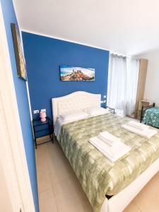 a bedroom with a large bed with a blue wall at Adam Eric in La Spezia