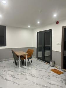 a dining room with a table and chairs on a marble floor at Cozy Corner Beach Hotel in Phú Quốc