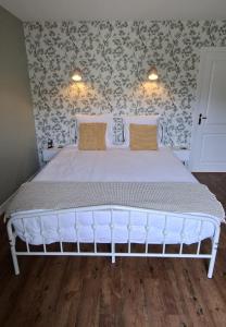 a white bed in a bedroom with a wall at B&B Le Chardon in Saint-Gervais-les-Trois-Clochers