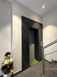 a hallway with a black wall with a door and a plant at Hotel sky inn in Jalandhar