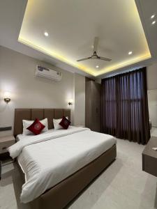 a bedroom with a large white bed with red pillows at Hotel sky inn in Jalandhar