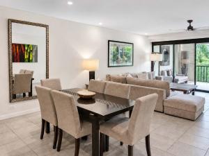 a living room with a couch and a table and chairs at Poolside Bliss: A Modern Resort Sanctuary in Port Douglas