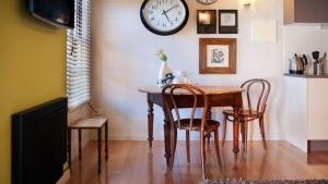 a dining room table with chairs and a clock on the wall at Circa Ruby Mint Daylesford in Daylesford