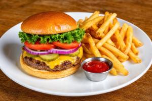 a plate with a cheeseburger and french fries with ketchup at Hotel Carl XII in Ed