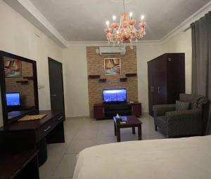 a room with a bed and a living room with a chandelier at فندق قمة البستان الرفاع in Arar