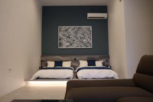 a bedroom with two beds and a couch at Mare Blu Amami in Tatsugo