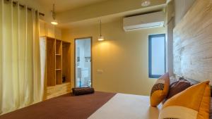 a bedroom with a bed and a window and a bathroom at Madivaru Kro in Rasdhoo
