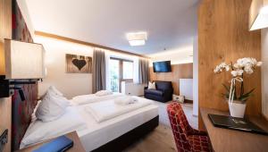 um quarto de hotel com uma cama e uma escrivaninha em Wellness Hotel Gran Risa***S em La Villa