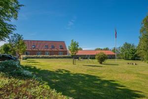 a building with a large field in front of it at Nordgården Pension in Onsbjerg