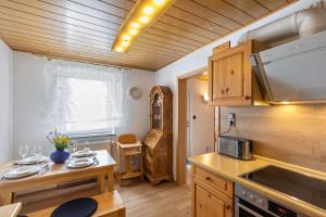 a kitchen with wooden cabinets and a table and a microwave at Auszeit im Grünen in Bad Schwalbach