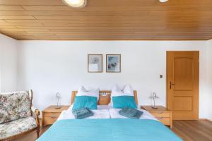 a bedroom with a blue bed and a chair at Auszeit im Grünen in Bad Schwalbach