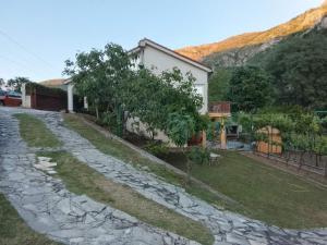 ein Haus mit Garten und Steinauffahrt in der Unterkunft Vila Arapović, Maloševići 56 in Buna
