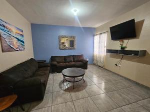 a living room with a couch and a tv at Depa 224pa con terraza alberca in San Carlos