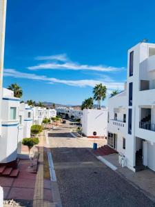 arial view of a street with white buildings and palm trees at Depa 224pa con terraza alberca in San Carlos