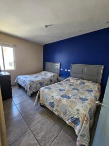 a bedroom with two beds and a baby laying on the floor at Depa 224pa con terraza alberca in San Carlos +5 photos