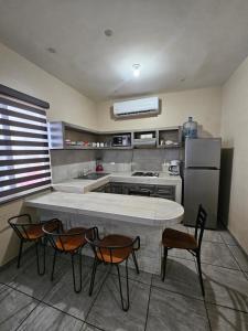 a kitchen with a table and chairs and a refrigerator at Depa 224pa con terraza alberca in San Carlos