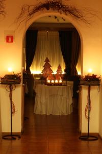 una stanza con tavolo con alberi di Natale e candele di Hotel Trieste a Cortina dʼAmpezzo