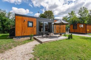 a small house with a patio and an umbrella at Holiday Home Tiny Haus Sunside in Riedenburg