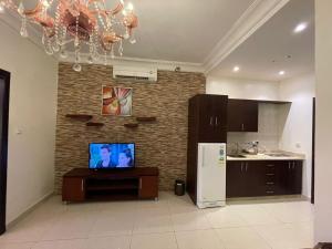 a kitchen with a refrigerator and a tv on a wall at فندق قمة البستان الرفاع in Arar