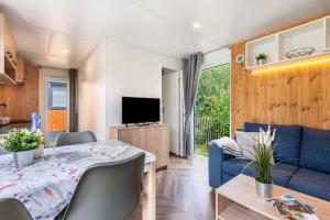 a kitchen and living room with a table and a blue couch at Holiday Home Tiny Haus Sunside in Riedenburg