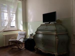 an old dresser with a television on top of it at Cascina Bolichin in Diano dʼAlba +4 photos