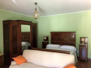 a bedroom with two beds and a mirror at Cascina Bolichin in Diano dʼAlba