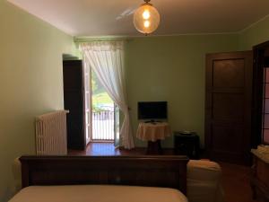 a bedroom with a bed and a window with a television at Cascina Bolichin in Diano dʼAlba