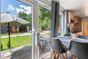 a kitchen and dining room with a table and an umbrella at Holiday Home Tiny Haus Sunside in Riedenburg