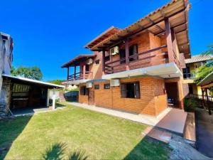 a brick house with a lawn in front of it at 001 1 Dormitorio Centro Bombinhas 400 m da praia in Bombinhas