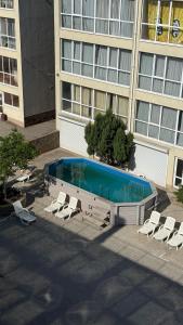 a swimming pool with lounge chairs in front of a building at Отель у моря Chester in Odesa